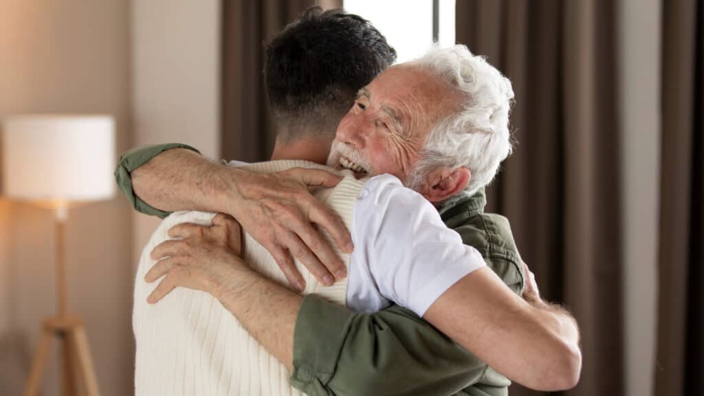 an old man hugging a young man symbolizing forgiveness