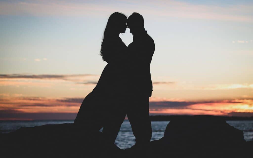 couple hugging at sunset with the space between them forming a heart symbolizing freedom from trauma