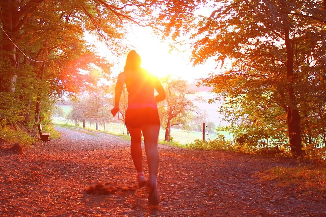 woman running into the sunset over fall leaves symbolizing her purpose