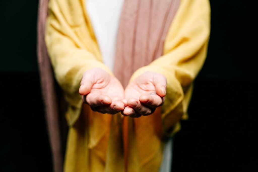 a person representing God with open hands symbolizing openness and giving